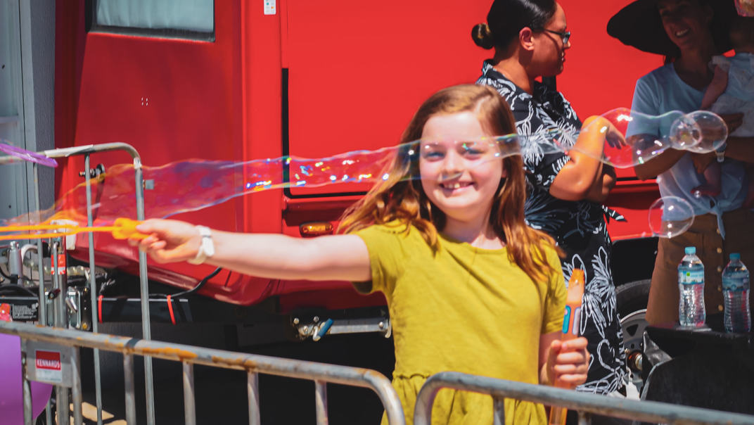 A young girl plays with bubbles at a Majestic picnic.